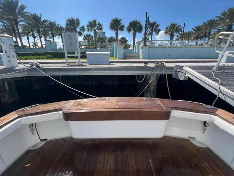 Slide: The Image of Stern view of 1997 Strike 42 boat docked, with wooden deck and palm trees in background. - 17