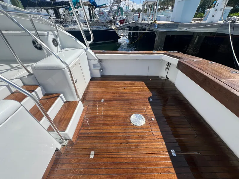 Slide: The Image of Spacious deck of 1997 Strike 42 boat with wooden flooring and dock view. - 18