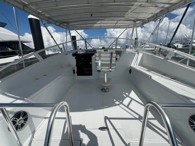 Slide: The Image of 1997 Strike 42 boat cockpit with seating, helm, and canopy under a clear sky. - 25