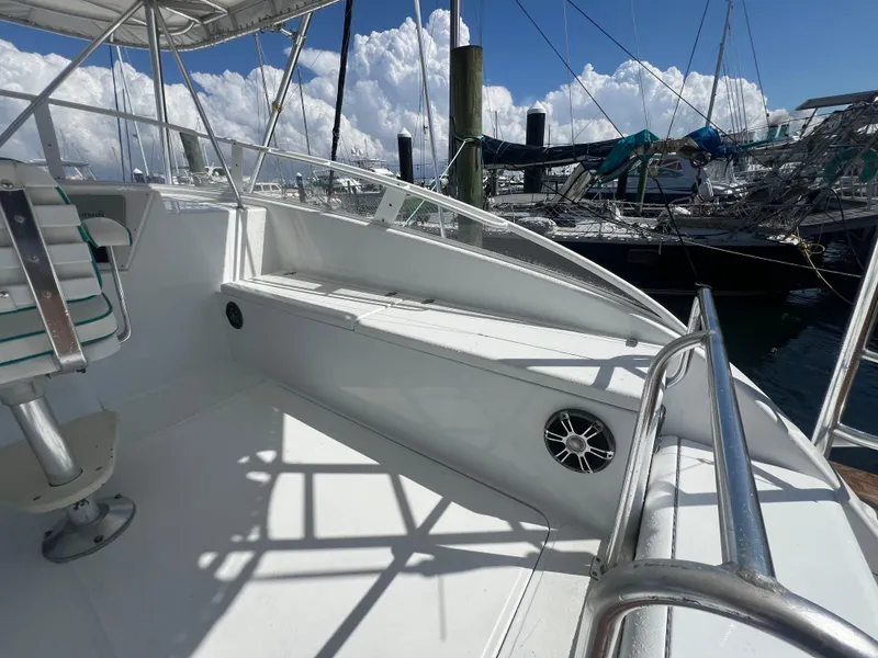 Slide: The Image of 1997 Strike 42 boat deck with seating, railing, and marina view under blue sky. - 27