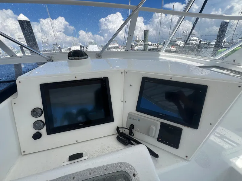 Slide: The Image of Control panel of a 1997 Strike 42 boat with navigation screens and gauges. - 35