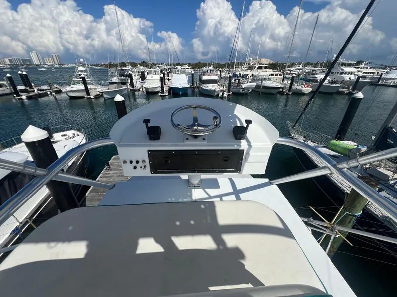 Slide: The Image of Helm of 1997 Strike 42 boat overlooking marina with docked yachts and blue sky. - 37