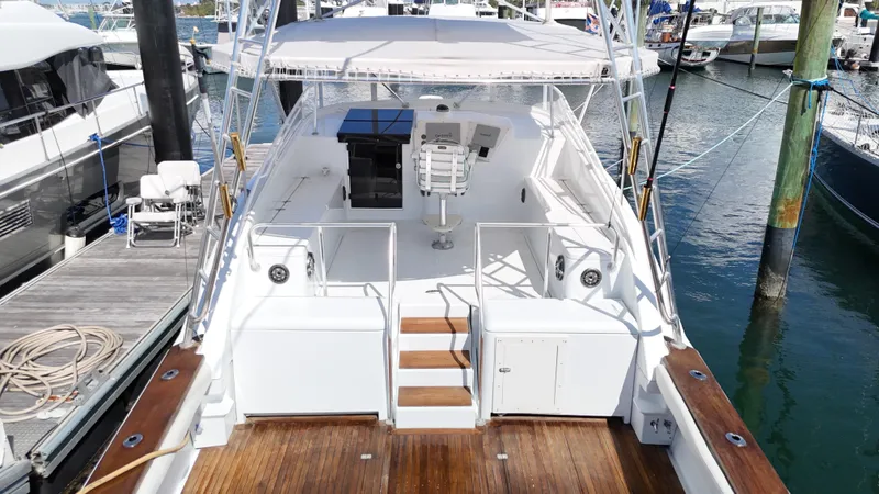 Slide: The Image of 1997 Strike 42 boat docked at marina, featuring spacious deck and seating area. - 7