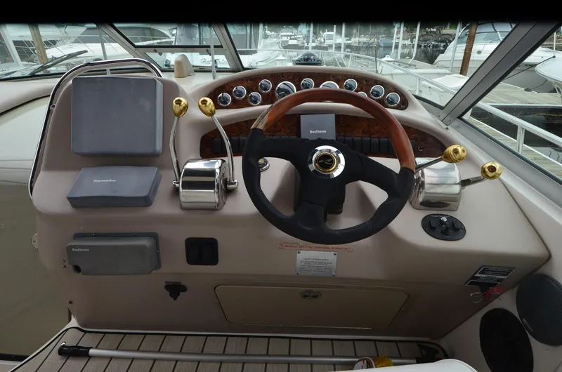 Slide: The Image of Helm of 2002 Sea Ray 340 Sundancer with wood-accented steering wheel and control panel. - 10