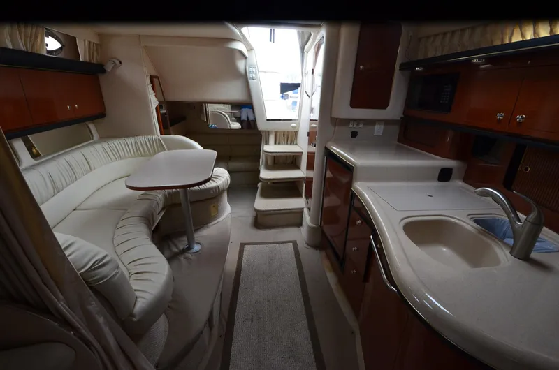 Slide: The Image of 2002 Sea Ray 340 Sundancer interior with kitchen, seating area, and stairs. - 13
