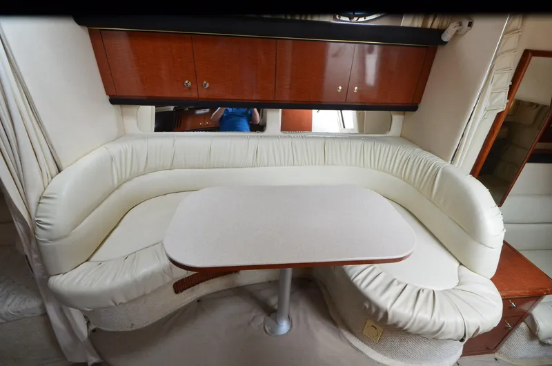 Slide: The Image of 2002 Sea Ray 340 Sundancer interior with white leather seating and wooden cabinetry. - 14