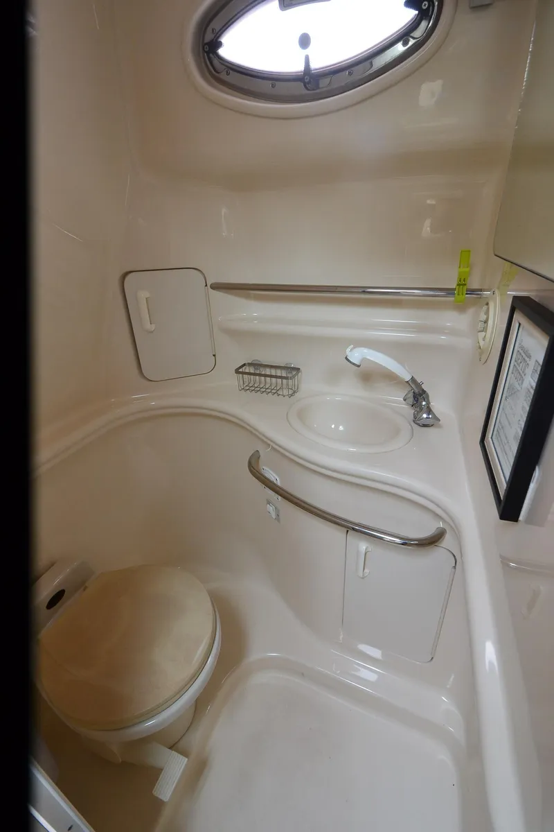 Slide: The Image of 2002 Sea Ray 340 Sundancer bathroom with sink, toilet, and porthole window. - 16