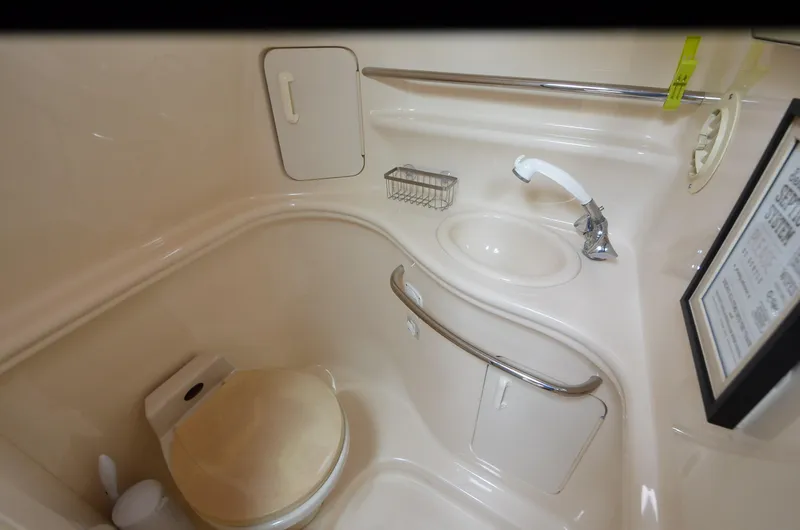 Slide: The Image of 2002 Sea Ray 340 Sundancer bathroom with toilet, sink, and storage. - 17