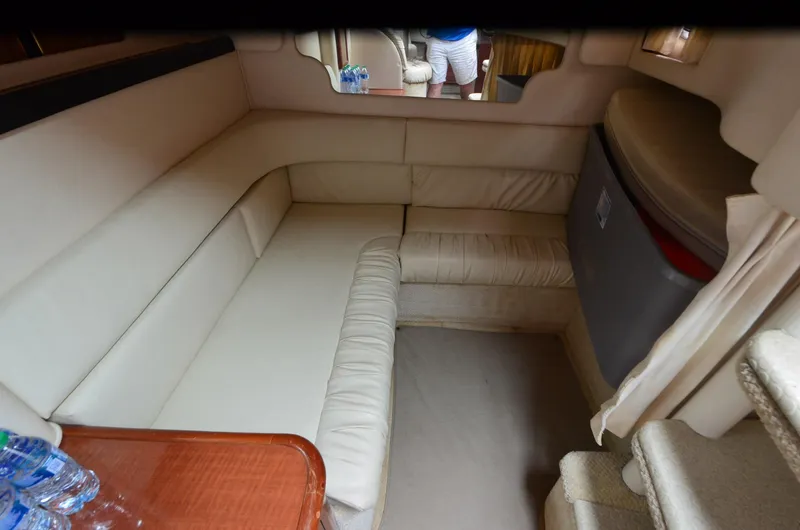 Slide: The Image of 2002 Sea Ray 340 Sundancer cabin interior with beige seating and wooden table. - 18