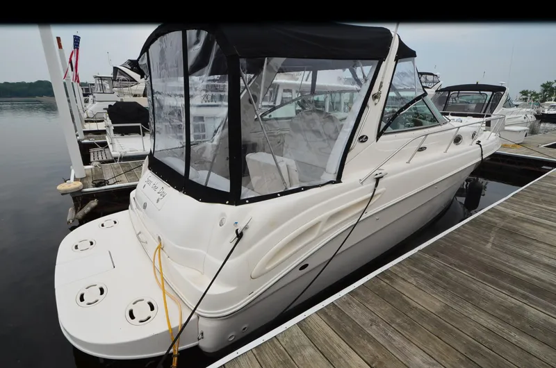 Slide: The Image of 2002 Sea Ray 340 Sundancer docked at marina, featuring sleek design and covered cockpit. - 2