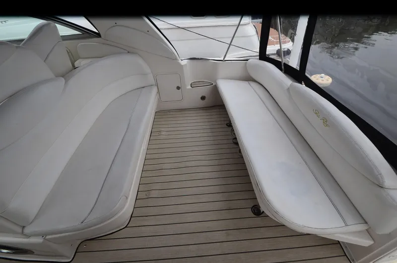 Slide: The Image of 2002 Sea Ray 340 Sundancer interior with white seating and wooden flooring. - 8