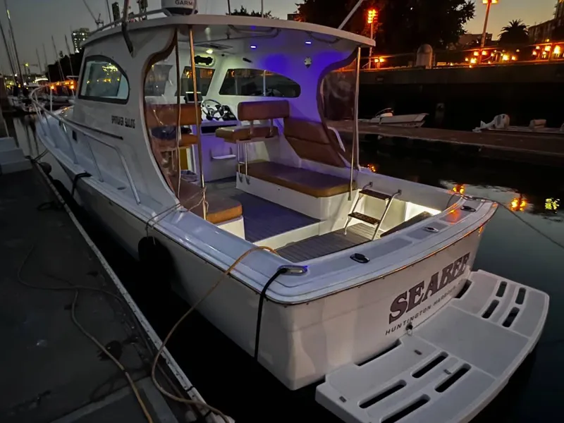 Slide: The Image of 1999 Mainship Pilot 30 boat docked at night with illuminated interior. - 0