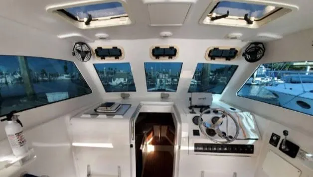 Slide: The Image of 1999 Mainship Pilot 30 boat interior with helm, windows, and nautical equipment. - 11