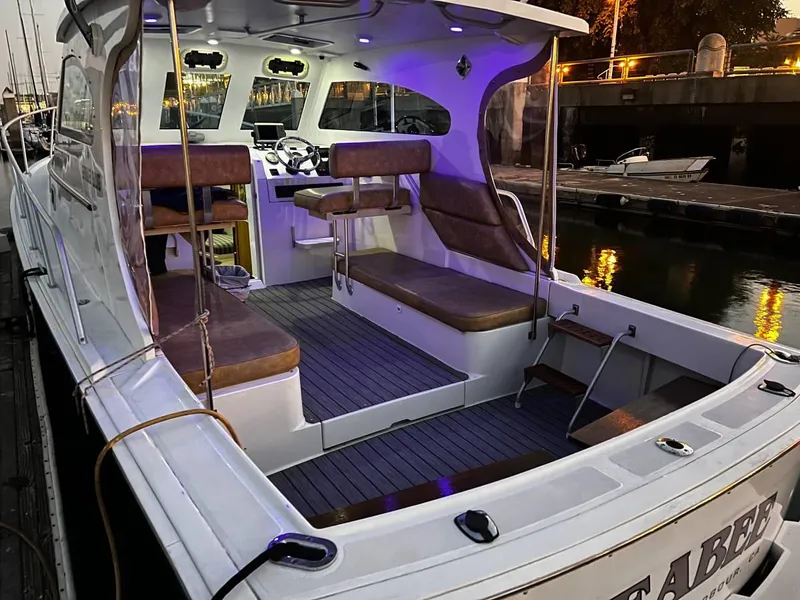 Slide: The Image of 1999 Mainship Pilot 30 boat with illuminated interior, docked at a marina during evening. - 20