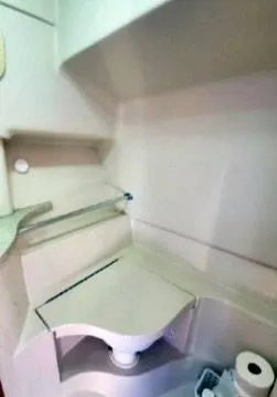 Slide: The Image of 1999 Mainship Pilot 30 boat interior with compact bathroom sink and storage shelves. - 5