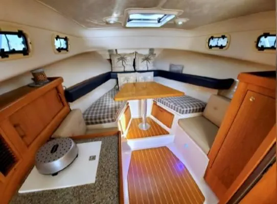Slide: The Image of 1999 Mainship Pilot 30 cabin interior with wood accents and cozy seating area. - 8