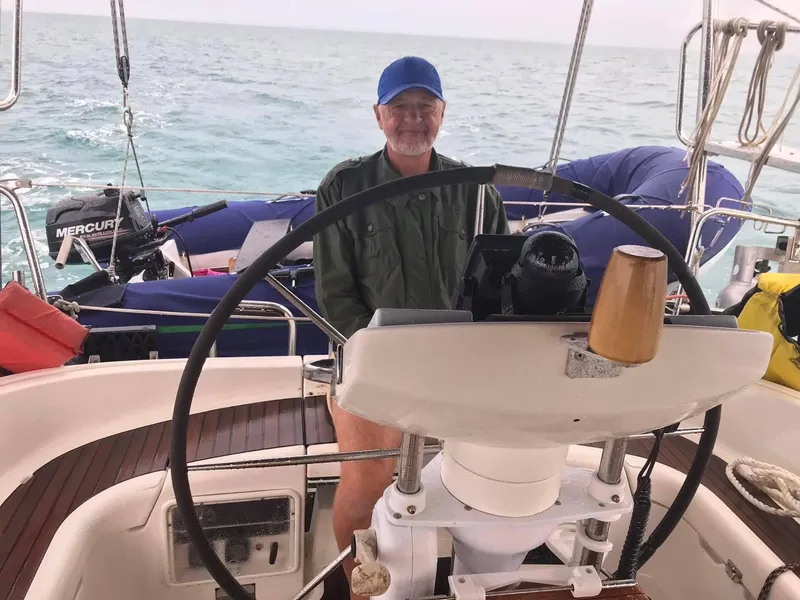 Slide: The Image of Man steering a 1997 Jeanneau Sun Odyssey 36.2 sailboat on open water. - 12