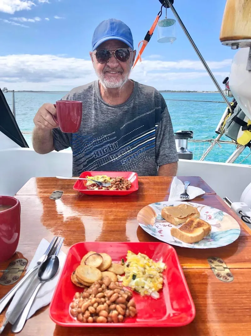 Slide: The Image of Man enjoying breakfast on Jeanneau Sun Odyssey 36.2 sailboat, 1997 model, with ocean view. - 13