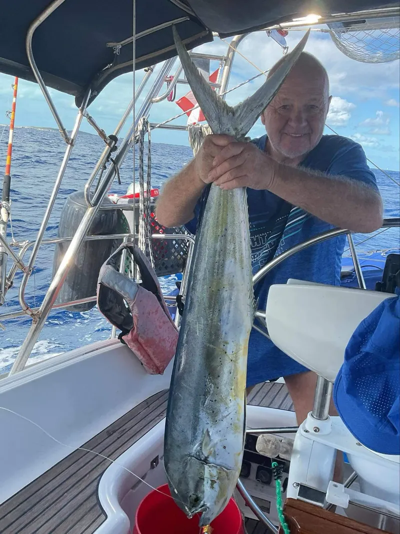 Slide: The Image of Man holding large fish on Jeanneau Sun Odyssey 36.2 sailboat, 1997 model, at sea. - 14