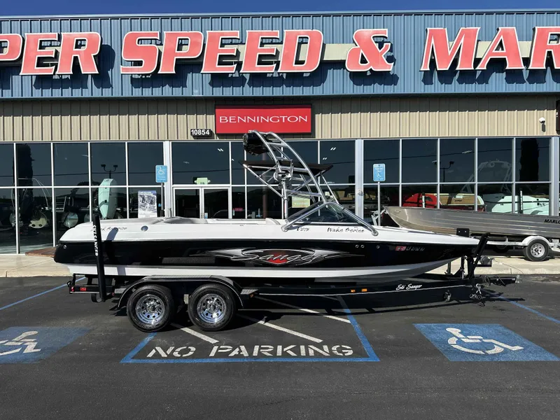 Slide: The Image of 2007 Sanger V215 boat on trailer outside marine store, parked in no parking zone. - 1