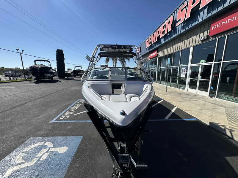 Slide: The Image of 2007 Sanger V215 boat parked outside dealership, sunny day, handicap parking visible. - 10