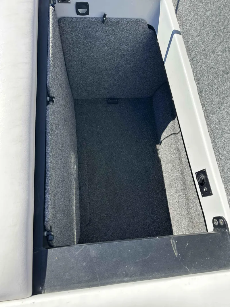 Slide: The Image of Storage compartment in a 2007 Sanger V215 boat, featuring gray interior lining. - 12