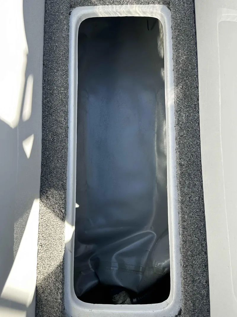 Slide: The Image of Storage compartment in a 2007 Sanger V215 boat, featuring a gray interior. - 18