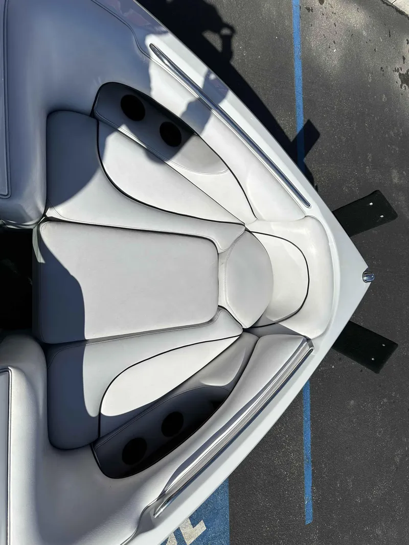 Slide: The Image of 2007 Sanger V215 boat interior with white cushioned seating and cup holders. - 19