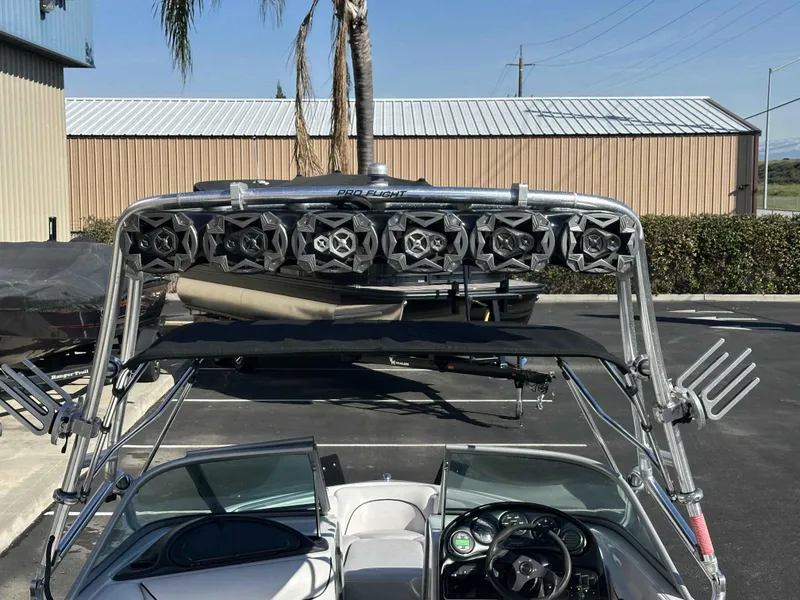 Slide: The Image of 2007 Sanger V215 boat with wakeboard tower and speakers in a parking lot. - 7