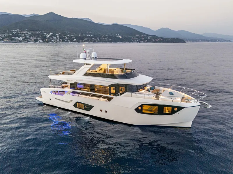 Slide: The Image of Luxurious 2026 Absolute 70' Navetta yacht cruising on serene waters at sunset. - 2