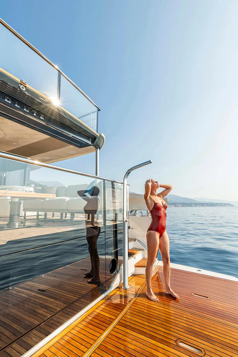 Slide: The Image of Woman in red swimsuit on Absolute 70' Navetta yacht, 2026 model, enjoying sunny day at sea. - 12