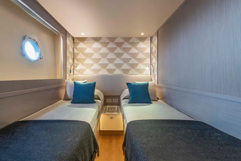 Slide: The Image of Luxurious twin cabin on 2026 Absolute 70' Navetta yacht with modern decor and porthole window. - 29