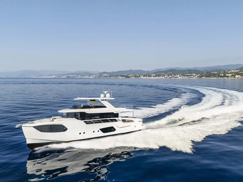 Slide: The Image of 2026 Absolute 70' Navetta yacht cruising on open water, creating a dynamic wake. - 6
