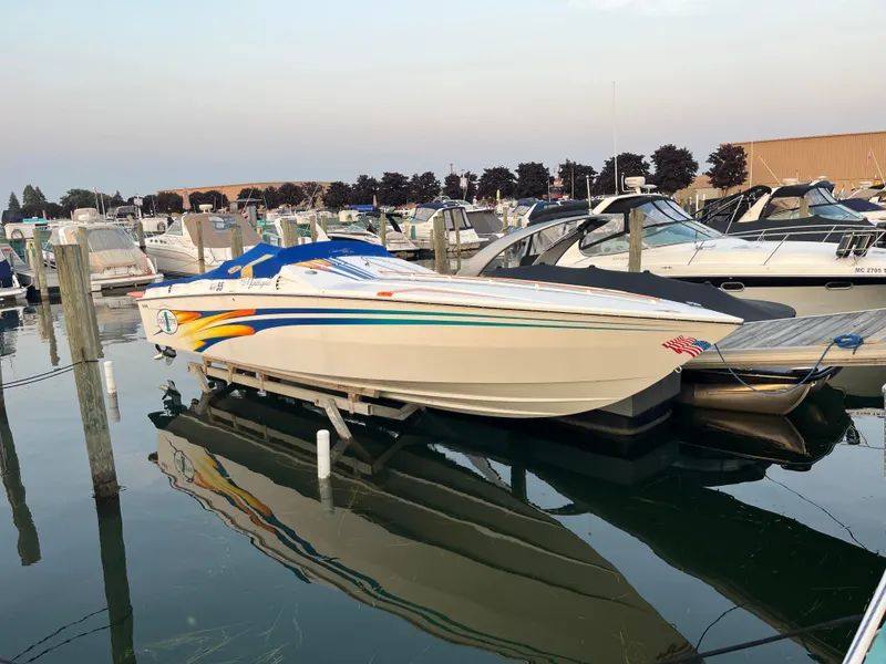 Slide: The Image of 2001 Cigarette Mystique boat docked in a marina, surrounded by other vessels. - 1
