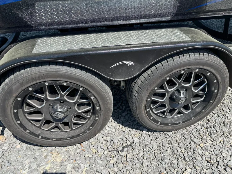 Slide: The Image of Dual black wheels on a 2023 Falcon F20 PREDATOR trailer, parked on gravel. - 16