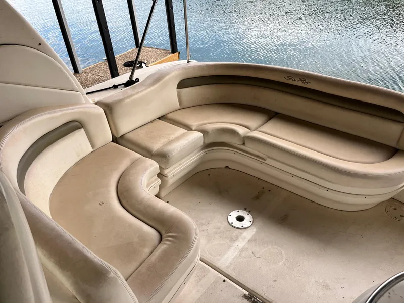 Slide: The Image of 2006 Sea Ray 340 Sundancer boat interior with beige seating by the water. - 10