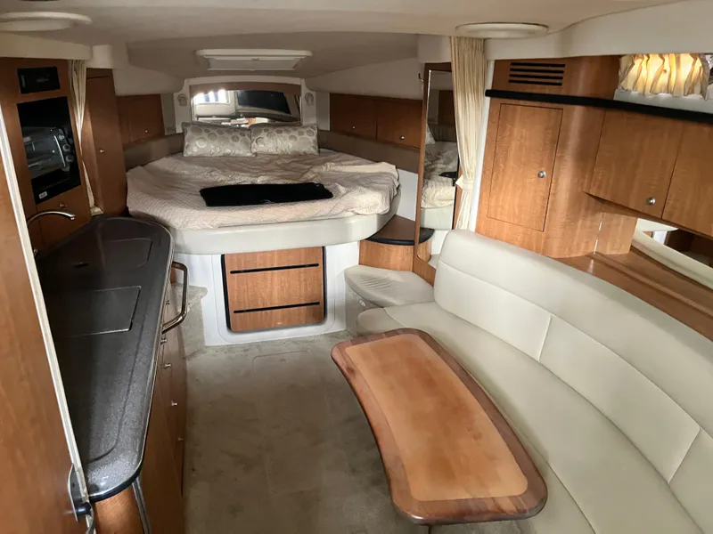 Slide: The Image of 2006 Sea Ray 340 Sundancer interior with bed, kitchenette, and seating area. - 15