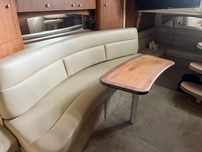 Slide: The Image of Interior of 2006 Sea Ray 340 Sundancer with beige seating and wooden table. - 18