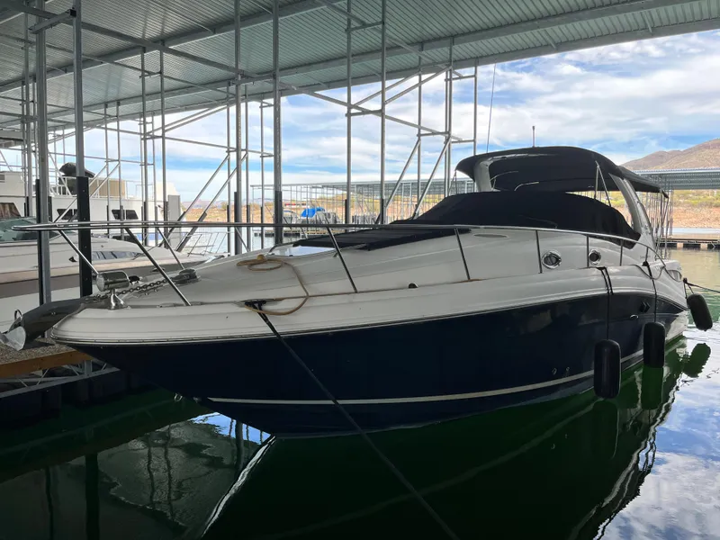 Slide: The Image of 2006 Sea Ray 340 Sundancer docked in a marina under a covered structure. - 2