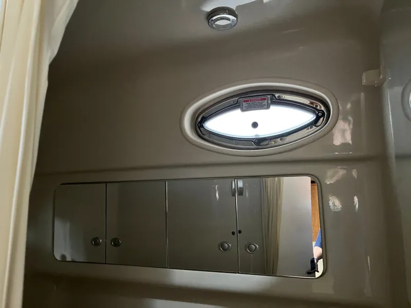 Slide: The Image of Interior cabin of 2006 Sea Ray 340 Sundancer with oval window and storage cabinets. - 23