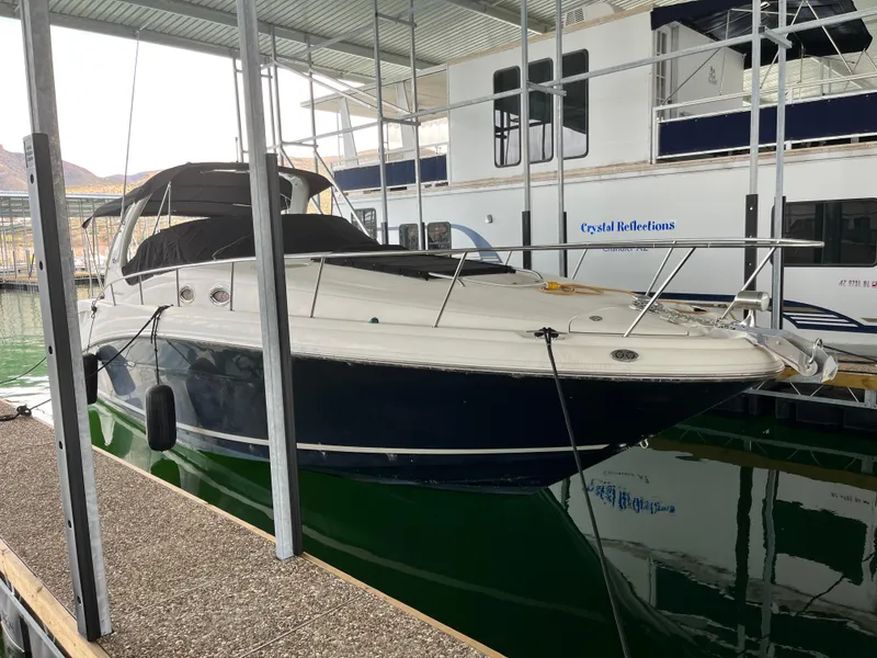 Slide: The Image of 2006 Sea Ray 340 Sundancer docked in a marina, featuring sleek design and covered seating. - 3