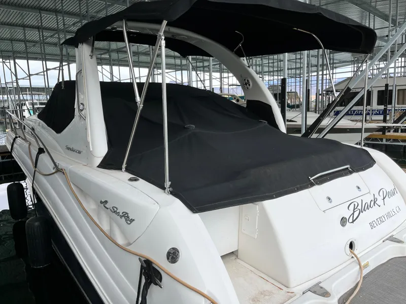 Slide: The Image of 2006 Sea Ray 340 Sundancer boat docked with black cover in marina. - 6