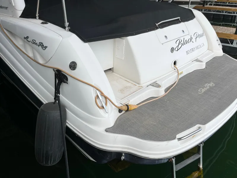 Slide: The Image of 2006 Sea Ray 340 Sundancer boat with black cover and docked at marina. - 7