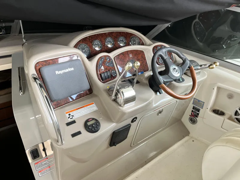 Slide: The Image of 2006 Sea Ray 340 Sundancer helm with Raymarine electronics and wood-accented dashboard. - 8