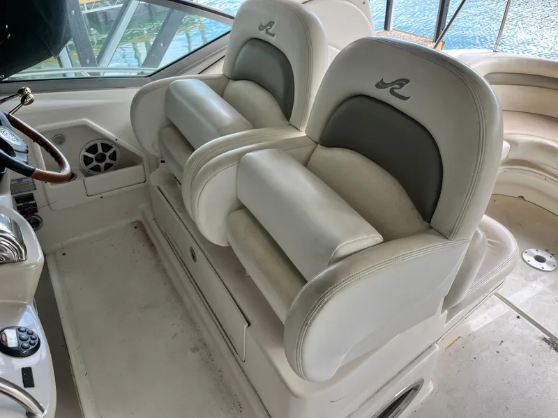 Slide: The Image of 2006 Sea Ray 340 Sundancer helm seats with white upholstery and logo detailing. - 9