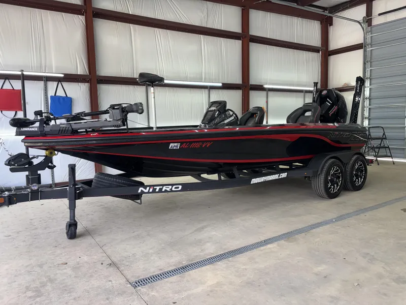 Slide: The Image of 2024 Nitro Z20 Pro bass boat in a garage, featuring sleek black and red design. - 2