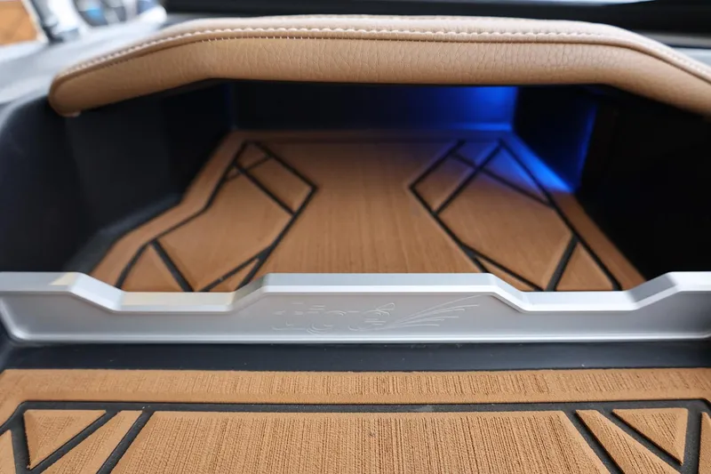 Slide: The Image of 2021 Tigé Z3 interior detail with brown and black accents, featuring blue ambient lighting. - 28
