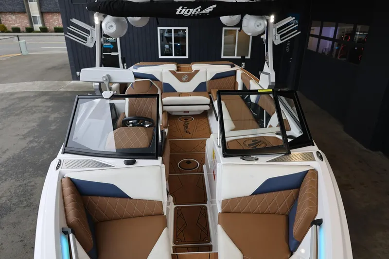 Slide: The Image of 2021 Tigé Z3 boat interior with brown and blue seating, open windshield, and modern design. - 31