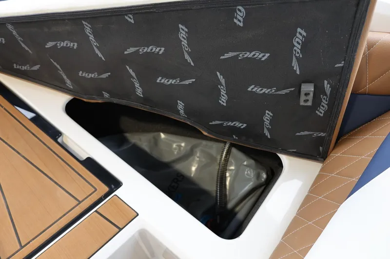 Slide: The Image of 2021 Tigé Z3 boat storage compartment with open lid, showcasing interior details. - 32