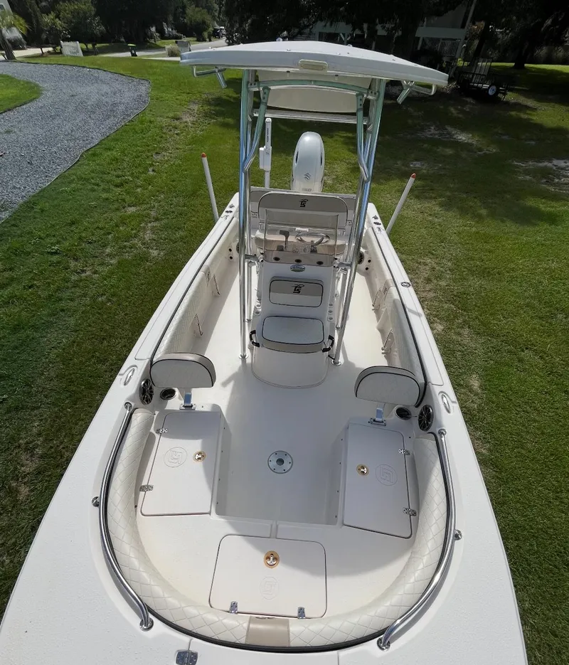 Slide: The Image of 2020 Carolina Skiff 21 Ultra Elite boat on grass, showcasing spacious deck and seating. - 17